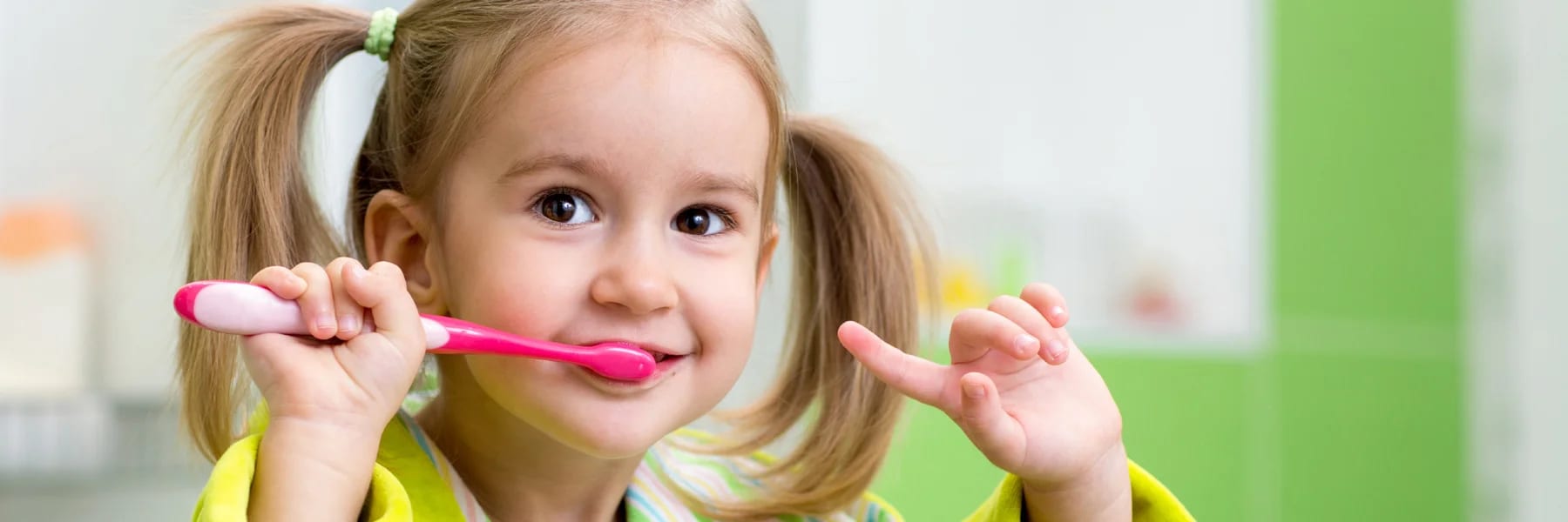 Niña sonriendo mientras se cepilla los dientes en Nins dental