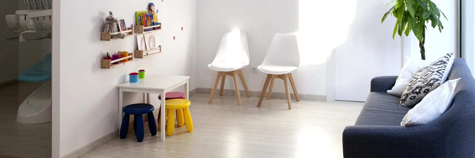 Sala de espera infantil de Nins dental, con sillas de colores para los más pequeños